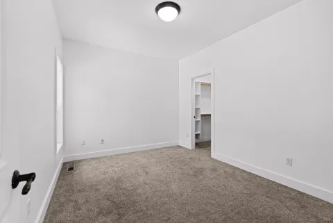 Carpeted room with a walk-in closet